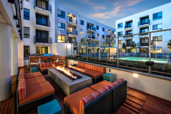 Outdoor lounge area with firepit overlooking apartment pool area 