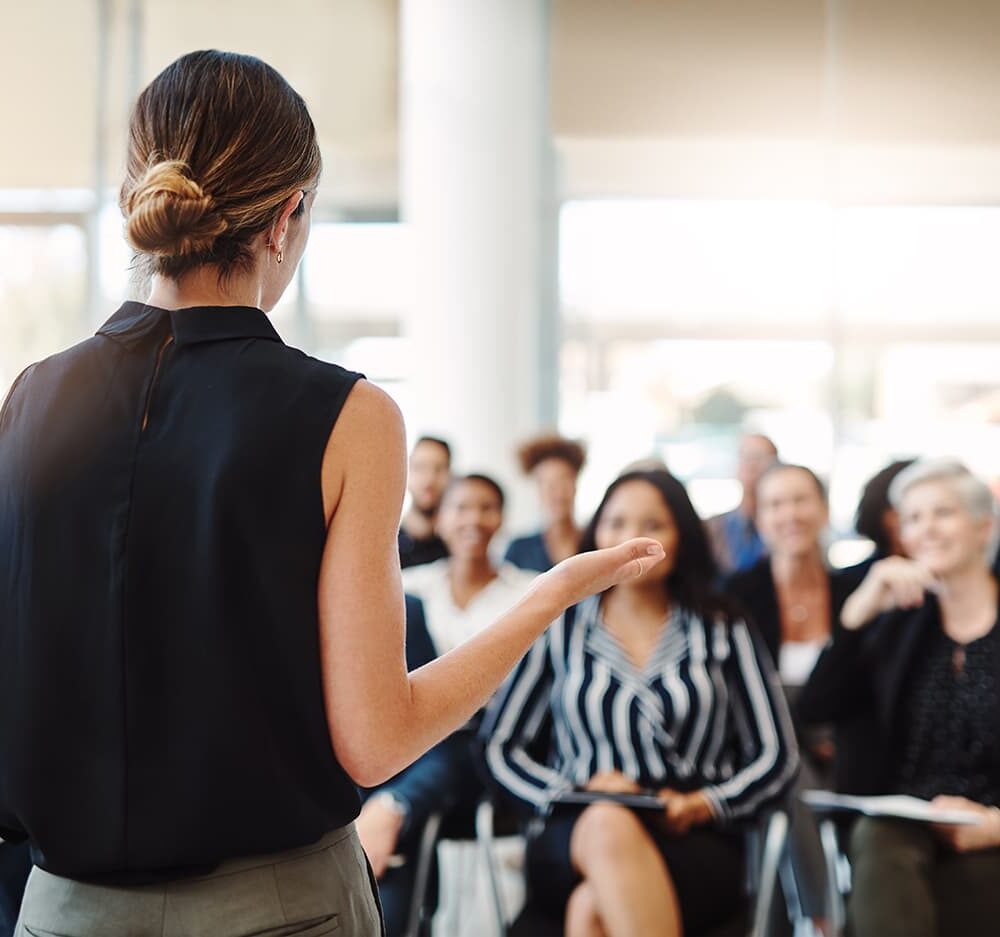 A woman speaks in front of a crowd