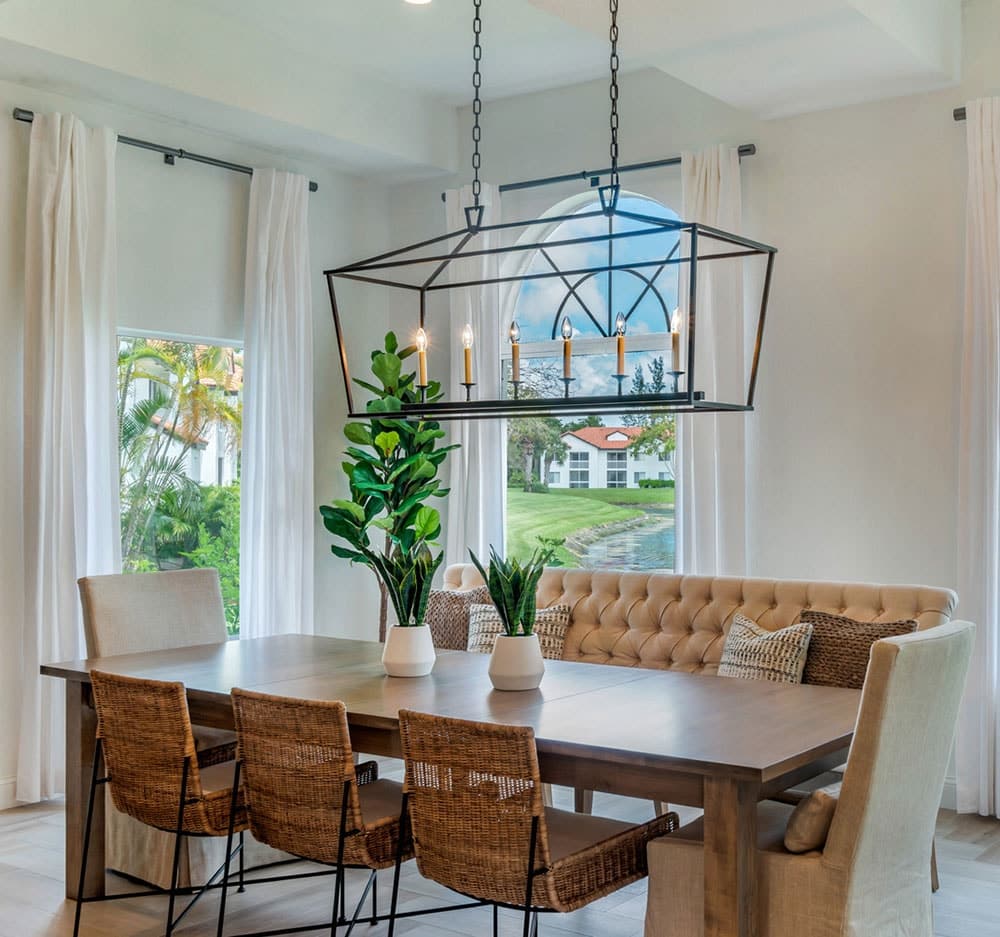 Modern dining room with long wooden table and tall windows