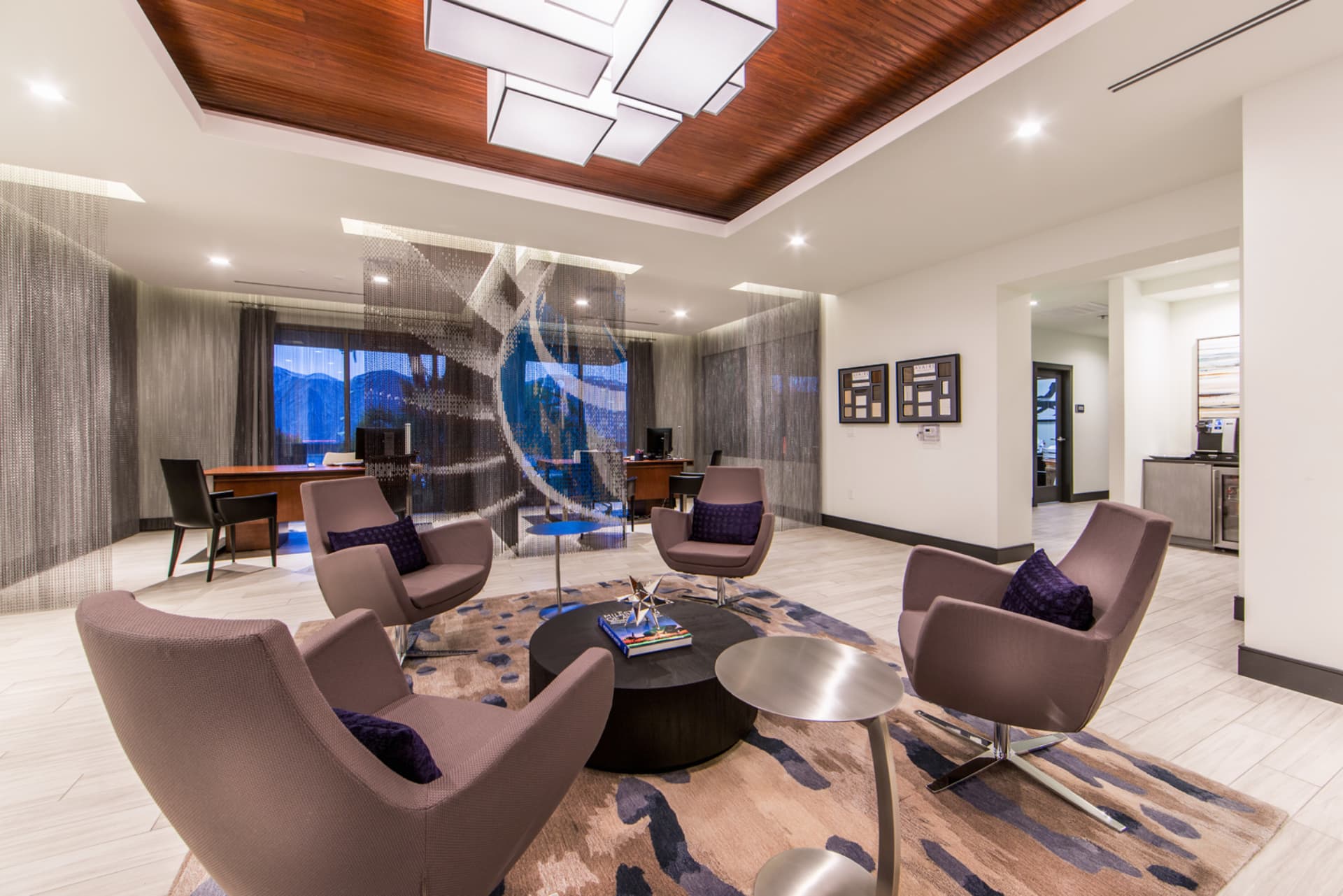 Waiting area with 4 cushioned chairs and desks in the background