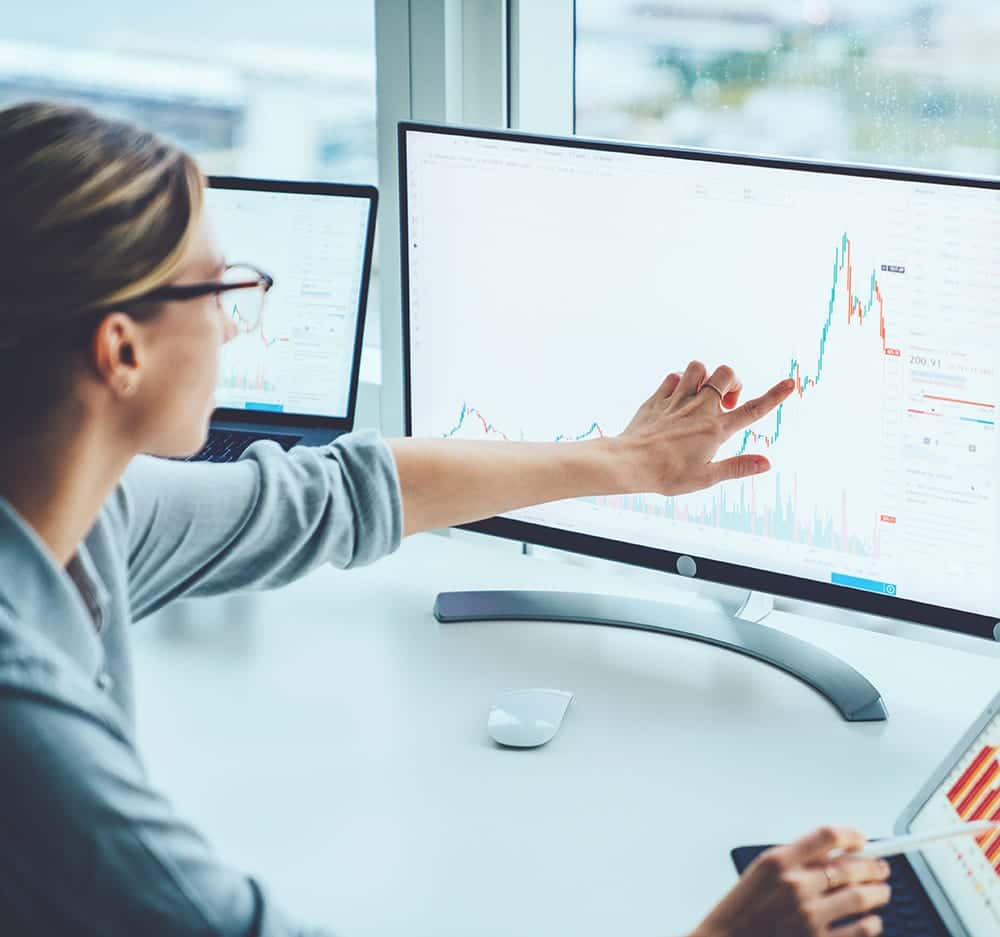 A woman with glasses uses a touchscreen computer