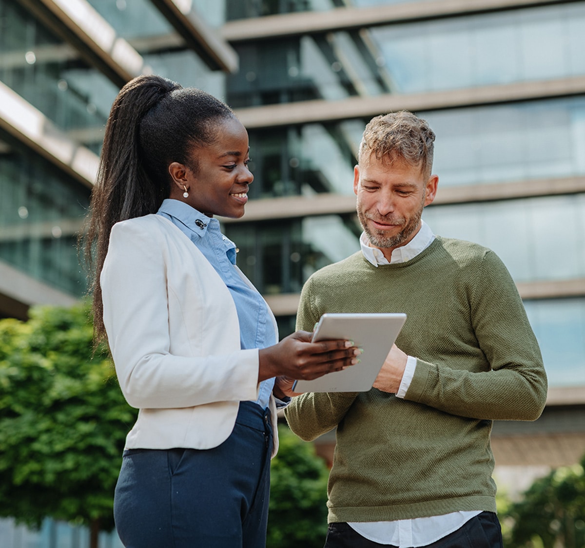 A woman shows a man the screen of an iPad